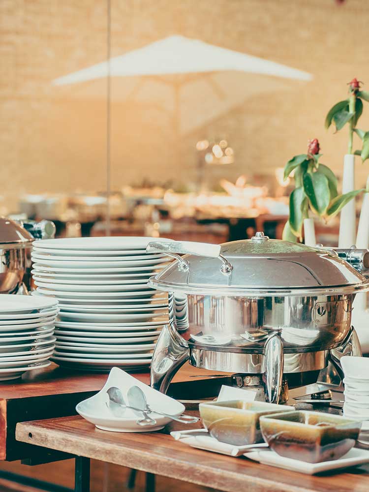 Arrangement of plates & chafing dishes in a Vegetarian catering set-up